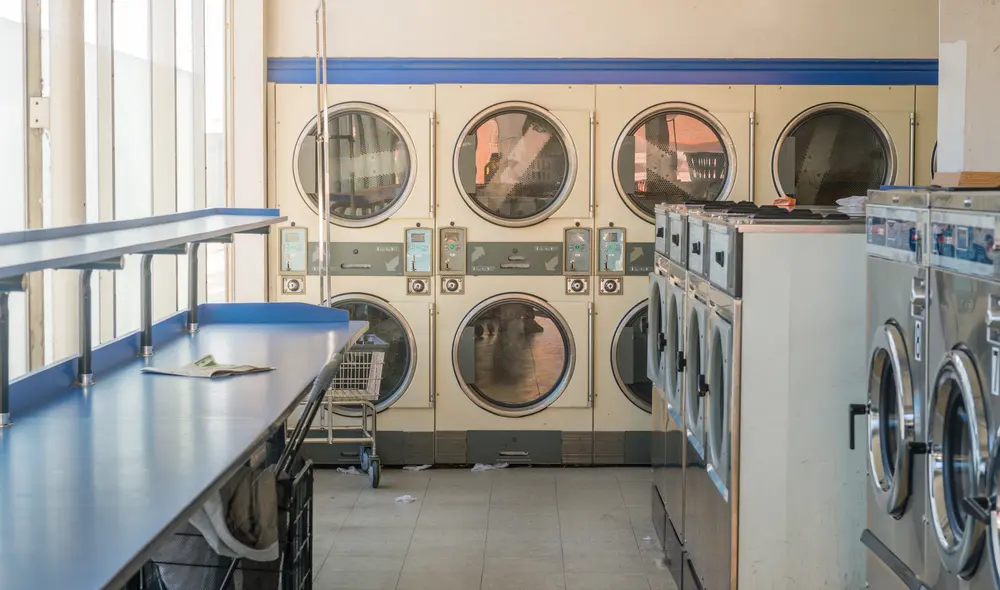 Spacious self-service laundromat facility featuring rows of clean, modern commercial washers and dryers